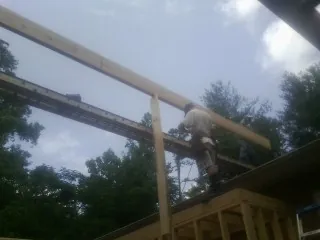 Carpenter setting a ridge beam over a new addition frame — Ice Dam Removal by Roofing Brothers in Highlands