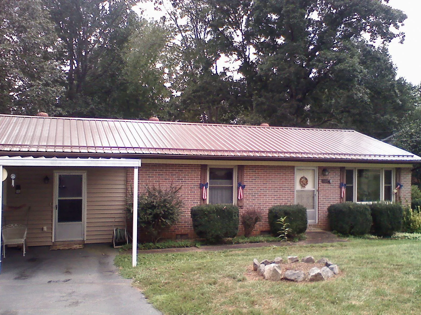 Bronze metal roof and carport on a brick ranch home — Roof Repair work by our crew in Highlands