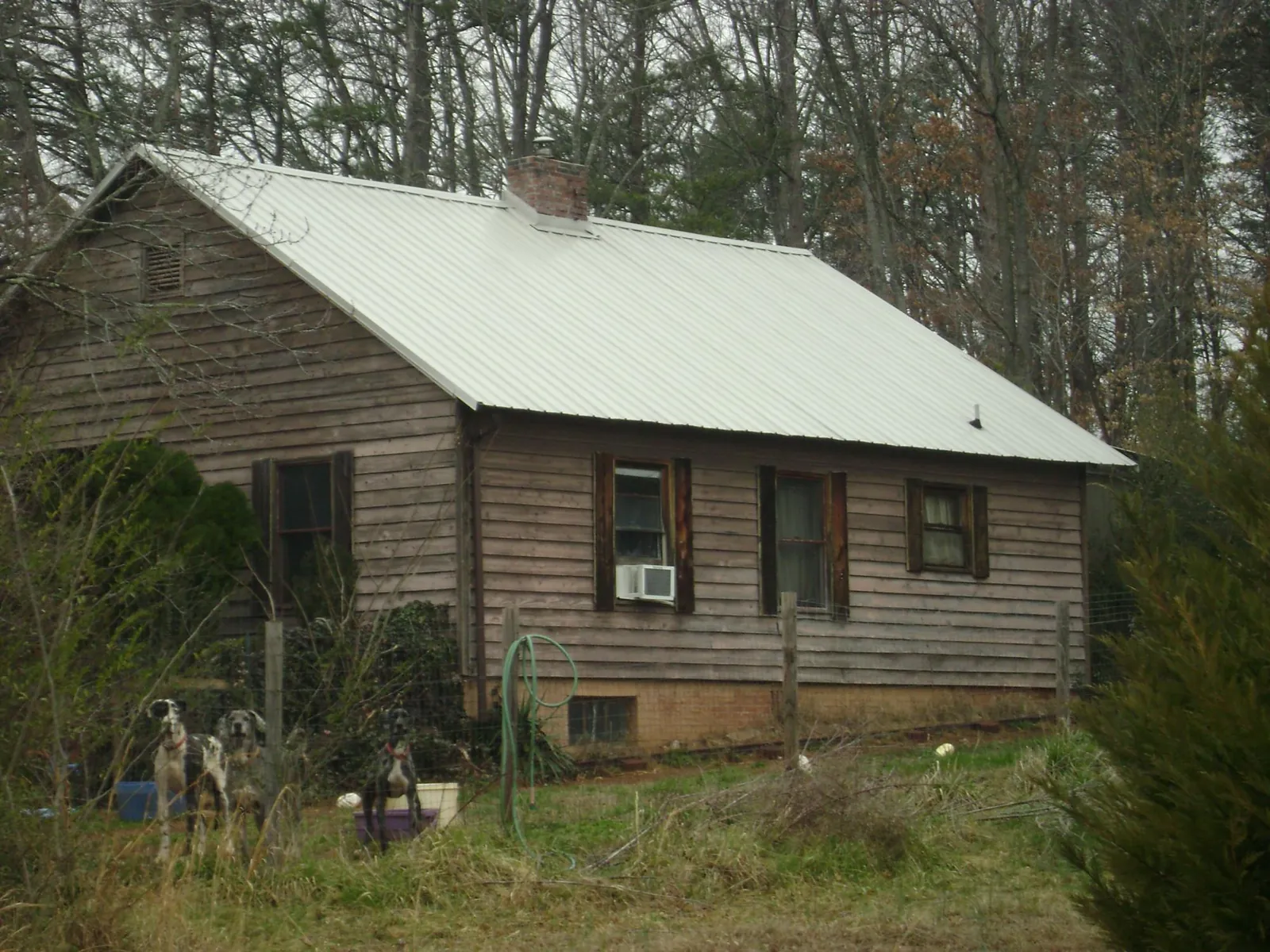 White metal roof on an old wood sided farmhouse, from a Metal Roof Installation job in Highlands